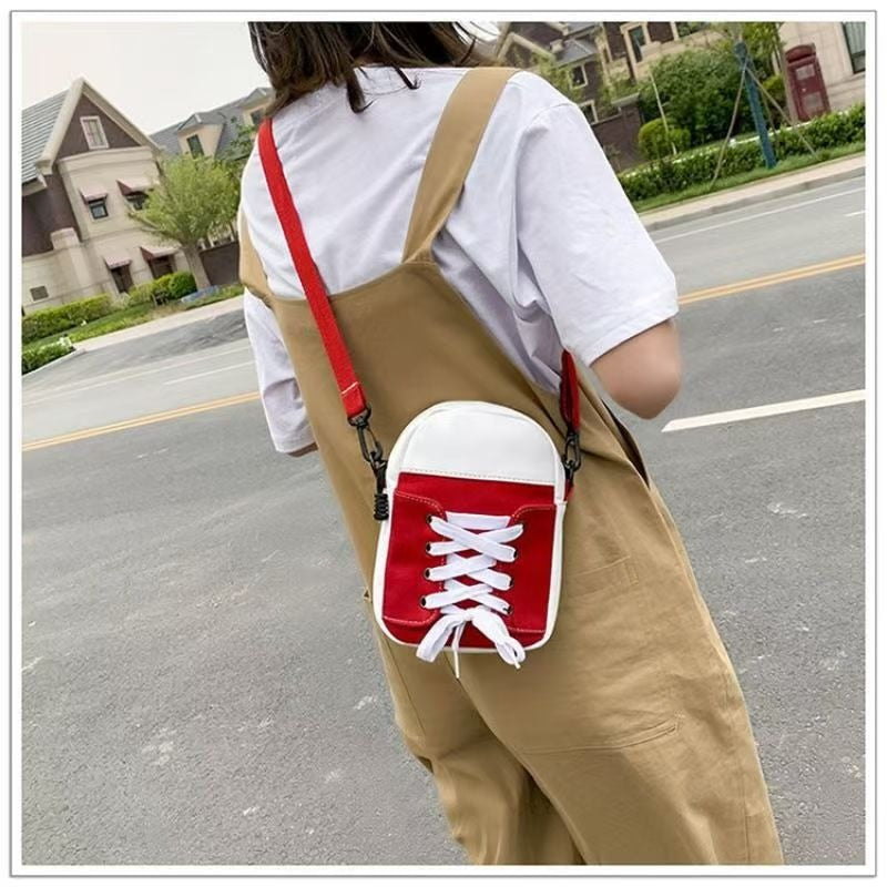 Model wearing red trainer shape canvas crossbody bag