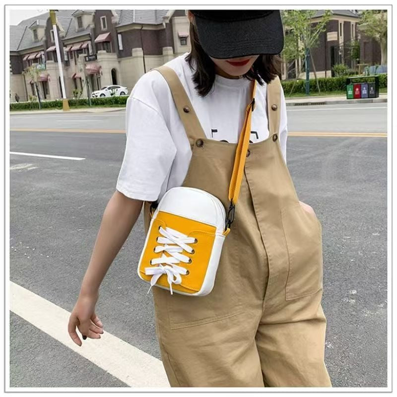 Model wearing yellow trainer shape canvas crossbody bag