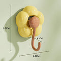 Yellow flower-shaped wall hook with brown hook and size measurements for home organization