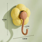 Yellow flower-shaped wall hook with brown hook and size measurements for home organization