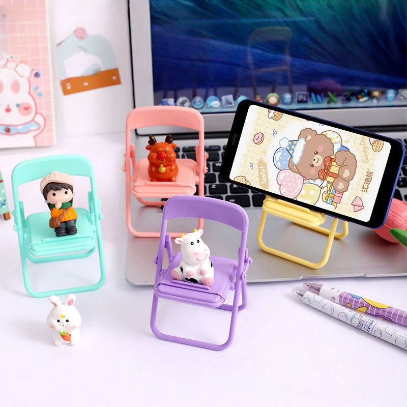 Cute pastel mini folding chair phone stands with animal and character figures on a desk