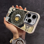 Hand holding a phone with a zodiac astrology design case featuring moon, sun, and cosmic motifs