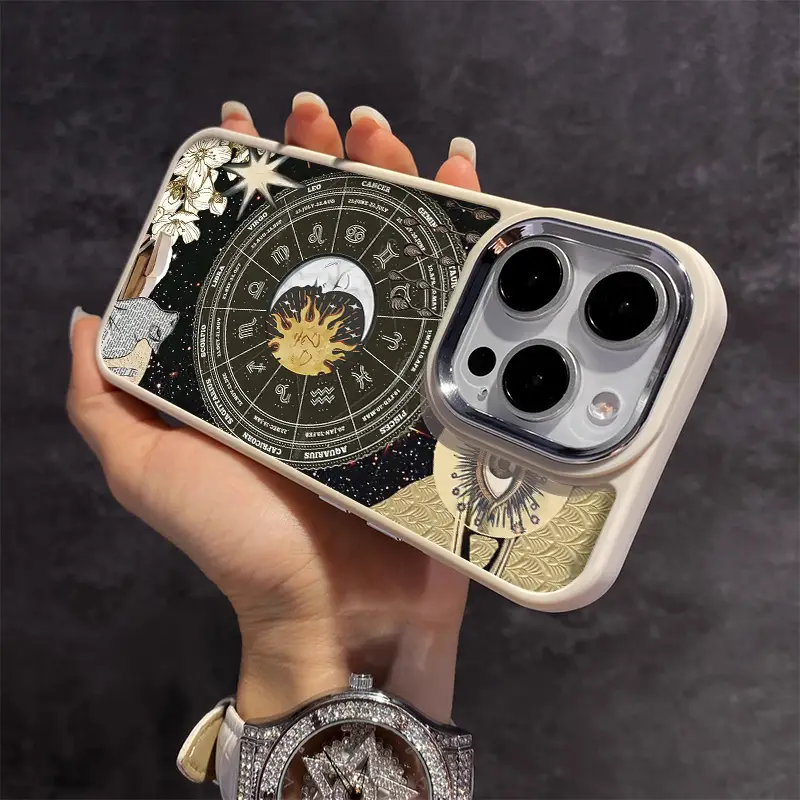 Hand holding a phone with a zodiac astrology design case featuring moon, sun, and cosmic motifs