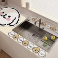 Modern kitchen sink with kawaii cartoon animal face mats and two apples on drying rack