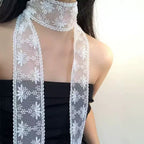 Narrow white lace ribbon scarf tied at the neck with both ends hanging long